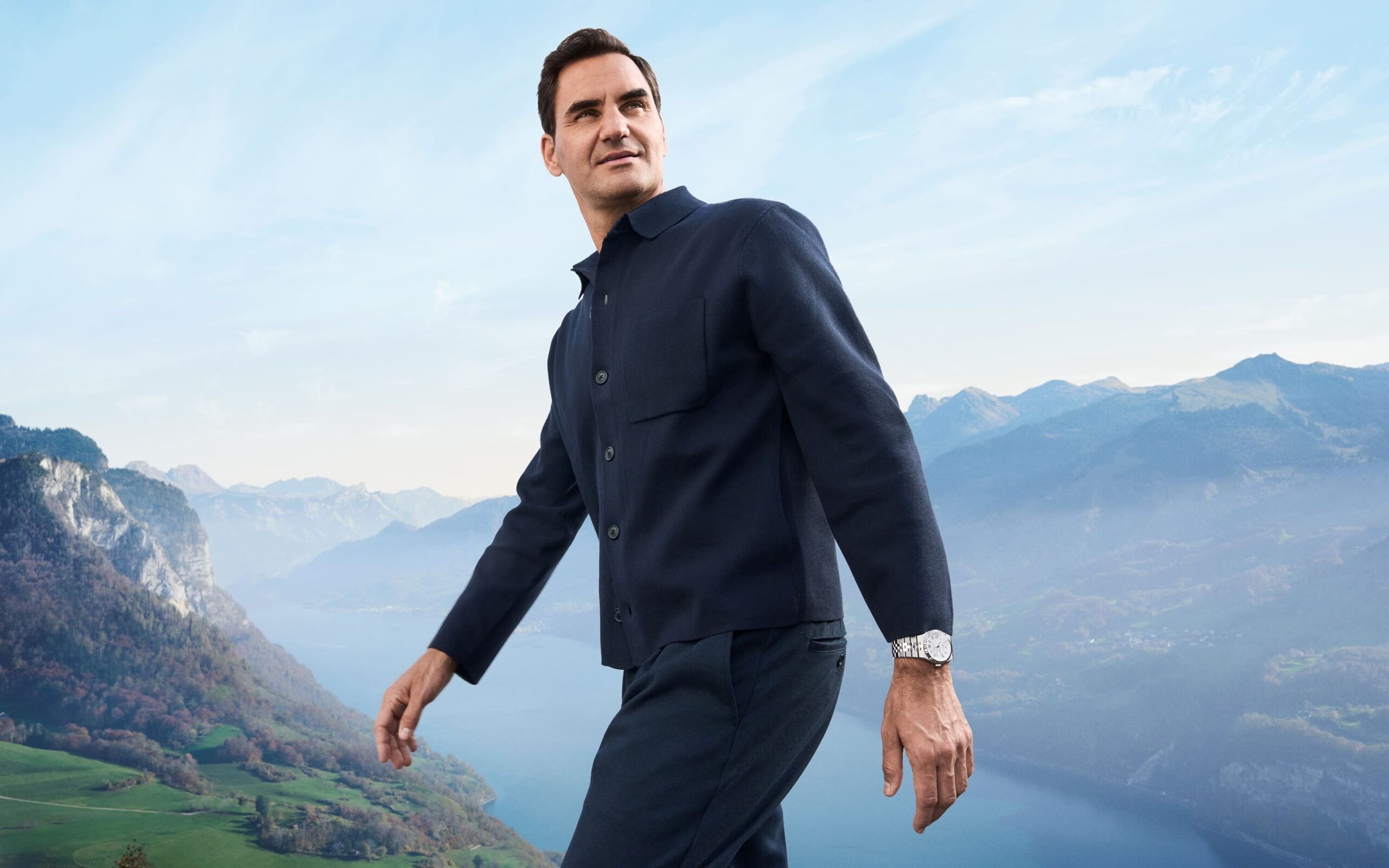 Roger Federer, embaixador da Rolex, usando um relógio Land-Dweller em um cenário montanhoso ao ar livre.
